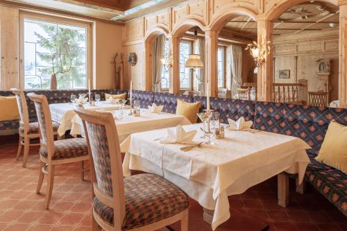蒂罗尔-泽费尔德赛乐酒店的餐厅设有2张桌子和椅子以及窗户。