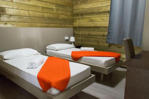 波利科罗Policoro Village Hotel的木墙客房 - 带两张单人床