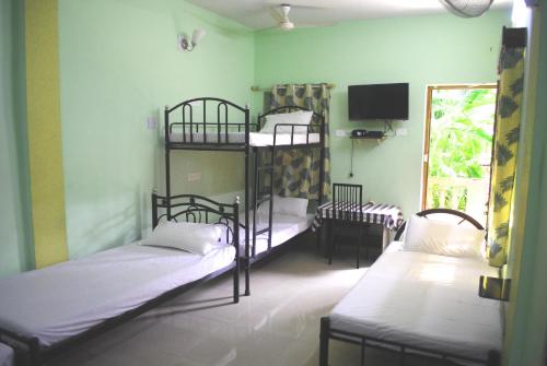 卡兰古特Joe And Marietta's Guesthouse的客房设有两张双层床和电视。