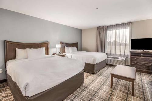 尤宁城MainStay Suites的酒店客房设有两张床和一台平面电视。