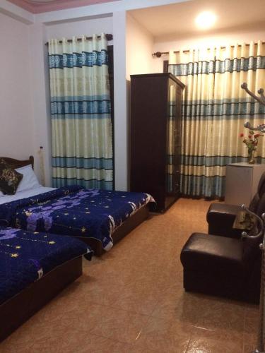 大叻Hostel Khanh Hương 2的一间卧室配有两张床、椅子和窗帘