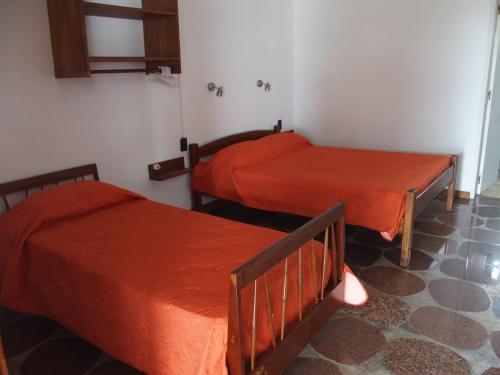 圣格雷戈里奥德波兰科Hotel Buena Vista Se reserva solo con seña的红色床单的客房内的两张床