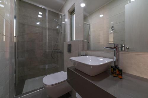 卡莱维斯Mistrali Suites & Apartments的一间带水槽、淋浴和卫生间的浴室