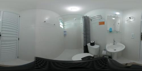 乌巴图巴Urbano Suítes的白色的浴室设有卫生间和水槽。