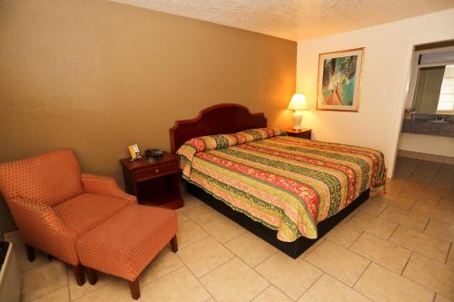 博蒙特得克萨斯州博蒙特旅馆的一间卧室配有一张床和一把椅子