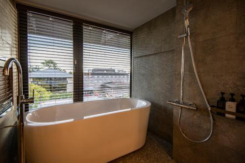 奈良AN-GRANDEホテル奈良的带浴缸的浴室和窗户
