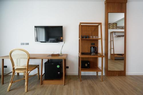 清迈Himku Hotel - adult only的客房设有书桌、电视和椅子