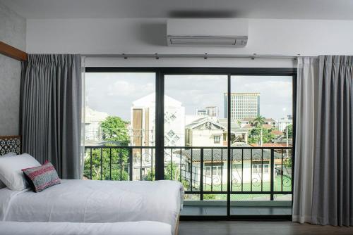 清迈Himku Hotel - adult only的酒店客房设有一张床和一个大窗户