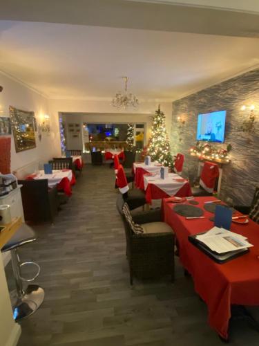 锡顿Mariners Hotel的用餐室配有桌椅和圣诞装饰