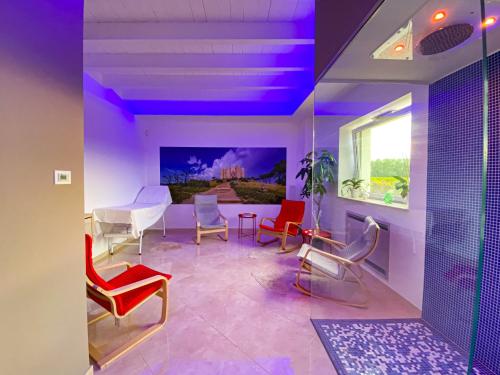 科拉托Tenuta Vigna del Noce的客厅配有五颜六色的椅子和桌子