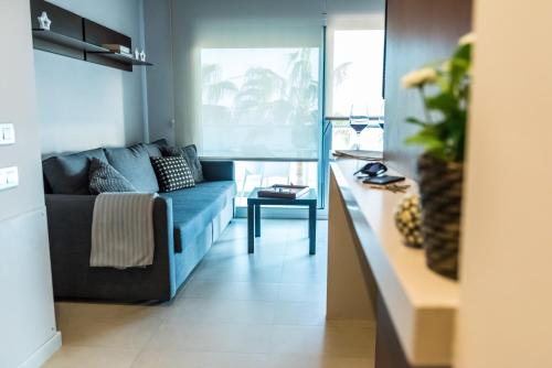 托里代巴拉Hauzify I Apartaments Grup Claustre的客厅配有蓝色的沙发和桌子