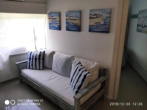 埃斯特角城Apartamento Marina de roosvelt con piscina climatizada的墙上挂着照片的沙发