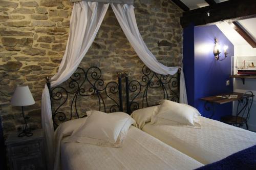 埃斯皮诺萨德洛斯蒙特罗斯La Casa Encanto的一间卧室配有一张带白色床单和窗帘的床