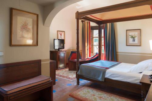 奥罗佩萨奥罗佩萨酒店的一间卧室配有一张天蓬床和一台电视机