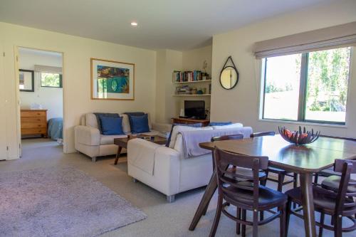 箭镇Arrowtown Country Cottage的客厅配有桌椅和沙发