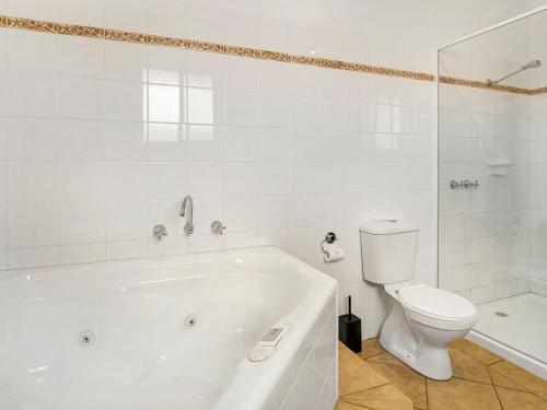 卡尔斯Beachfront Penthouse Cowes的白色的浴室设有浴缸和卫生间。