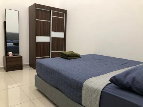 居銮CasaStayz Kluang的一间卧室配有蓝色的床和木制橱柜