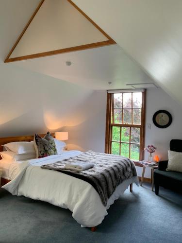 纳尔逊Quail Farm, Colonial charm的一间卧室设有一张大床和一个窗户。