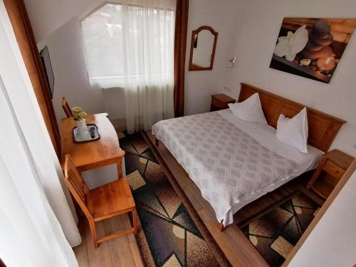 布什泰尼Casa Magica Busteni的一间小卧室,配有一张床和一张桌子