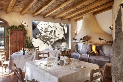 阿尔扎凯纳Tenuta Pilastru Country Resort & Spa的一间带2张桌子和壁炉的用餐室
