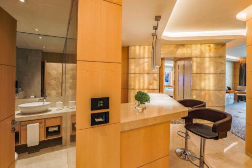 迪拜The Meydan Hotel Dubai的厨房配有水槽和带凳子的台面