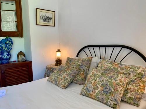七城Stone House - Sete Cidades的卧室配有带枕头和灯的白色床