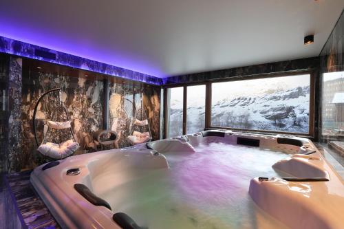布勒伊-切尔维尼亚Chalet Blanc的设有一个大浴缸的大窗户