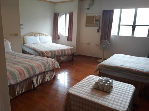 白河宏嶺溫泉山莊的酒店客房设有两张床和一张桌子。