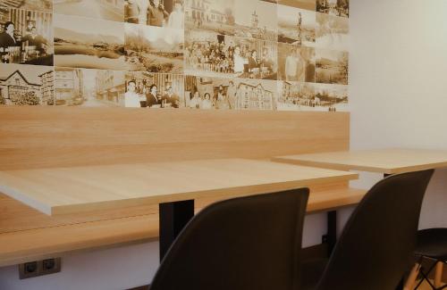 阿穆里奥Pensión Ayala的一间会议室,配有两张桌子和一面带照片的墙壁