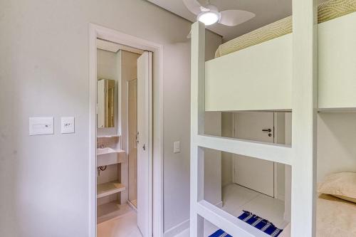 圣塞巴斯蒂安C15 - Conforto junto a natureza - Camburyzinho的卧室配有白色橱柜和镜子