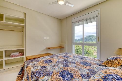 圣塞巴斯蒂安D16 - Conforto junto a natureza - Praia de Camburyzinho的一间卧室设有一张床和一个窗口
