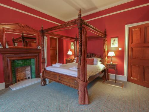 巴拉特Braeriach - Mar Lodge Estate的一间卧室设有四柱床和一个壁炉