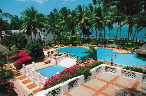 蒙巴萨思瑞娜海滩度假酒店的享有棕榈树度假村游泳池的空中景致