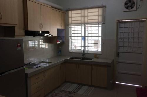 艾尔克如Homestay Ayi的厨房配有白色橱柜、水槽和窗户。