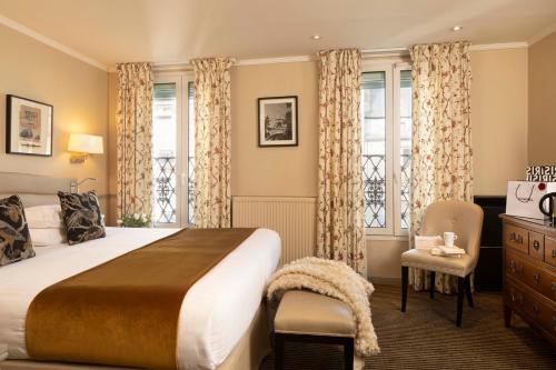 巴黎Hotel Relais Bosquet by Malone的一间卧室配有一张床、一把椅子和窗户。