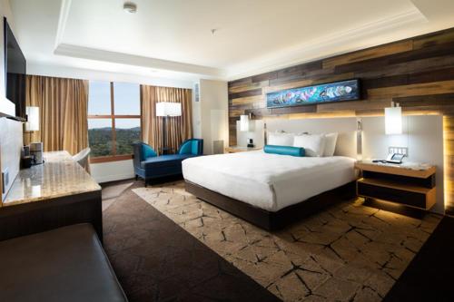 科斯戈尔德Chukchansi Gold Resort & Casino的酒店客房配有一张床、一张书桌和一张沙发。