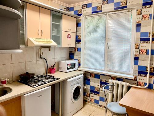切尔尼戈夫Апартаменты в центре по проспекту Победы парковка рядом的厨房配有洗衣机和微波炉。