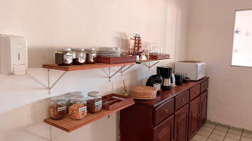 费尔南多 - 迪诺罗尼亚Pousada Brisa Mar的厨房配有木制架子和罐子食品