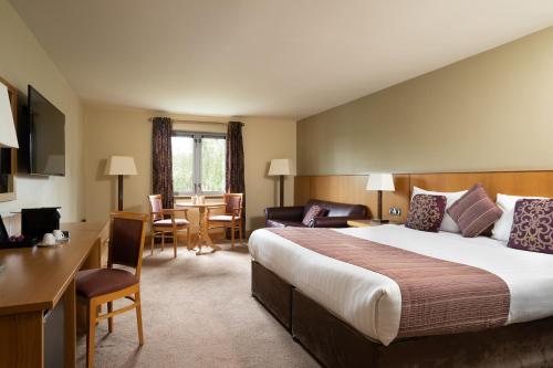 恩尼斯基林贝尔蒙酒店的酒店客房设有一张大床和一张书桌。