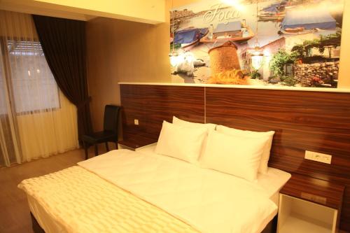 伊兹密尔Lucid Hotel酒店的卧室配有一张床,墙上挂有绘画作品