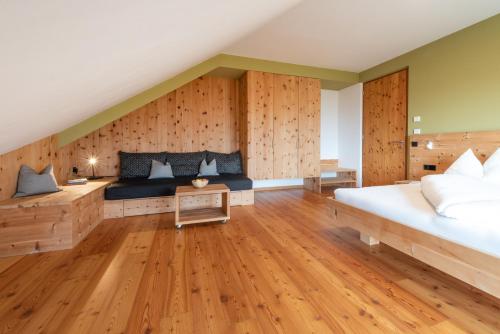 卡尔达罗Biobauernhof St. Quirinus的一间卧室设有一张大床和木墙