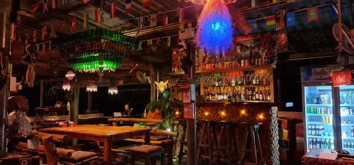 库德岛库德岛木小屋旅馆的酒吧设有木桌和调酒师
