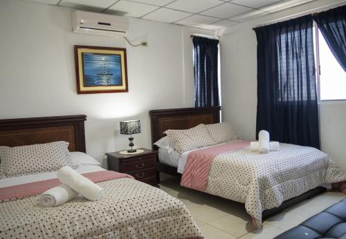 普拉亚斯Hotel Valeritos的一间卧室设有两张床和窗户。