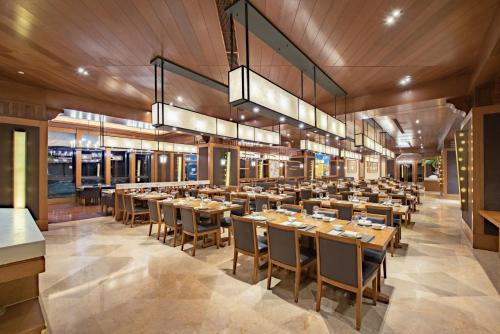 抚松县长白山万达锦华套房酒店 的大型用餐室配有桌椅