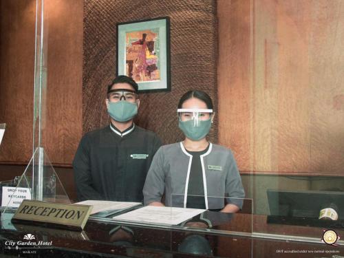马尼拉城市花园马卡蒂酒店的两个人戴面具坐在一张桌子上