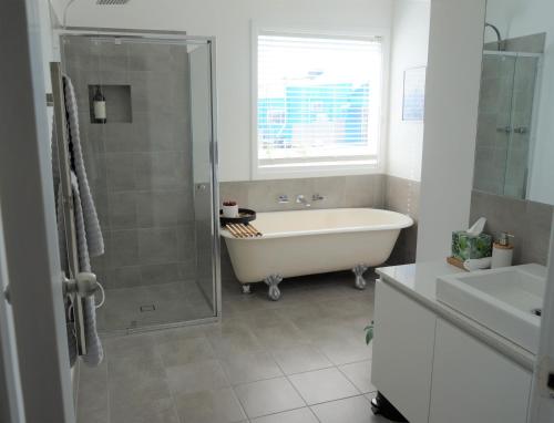 奥尔巴尼Retreat的带浴缸、淋浴和盥洗盆的浴室