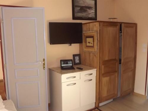 拉瓦勒马诺尔鲁斯酒店的一间带电视、橱柜和门的卧室