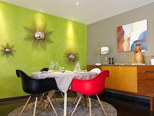 南希勒克洛斯亚农酒店的一间带桌子和两张红色椅子的用餐室