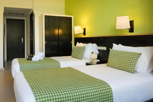 巴塞罗那htop BCN City #htopEnjoy的绿墙旅馆客房的两张床