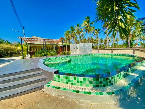 班武里府ศรีสุภาวดีรีสอร์ท-Srisupawadee resort的度假村内一个铺有绿色瓷砖的游泳池
